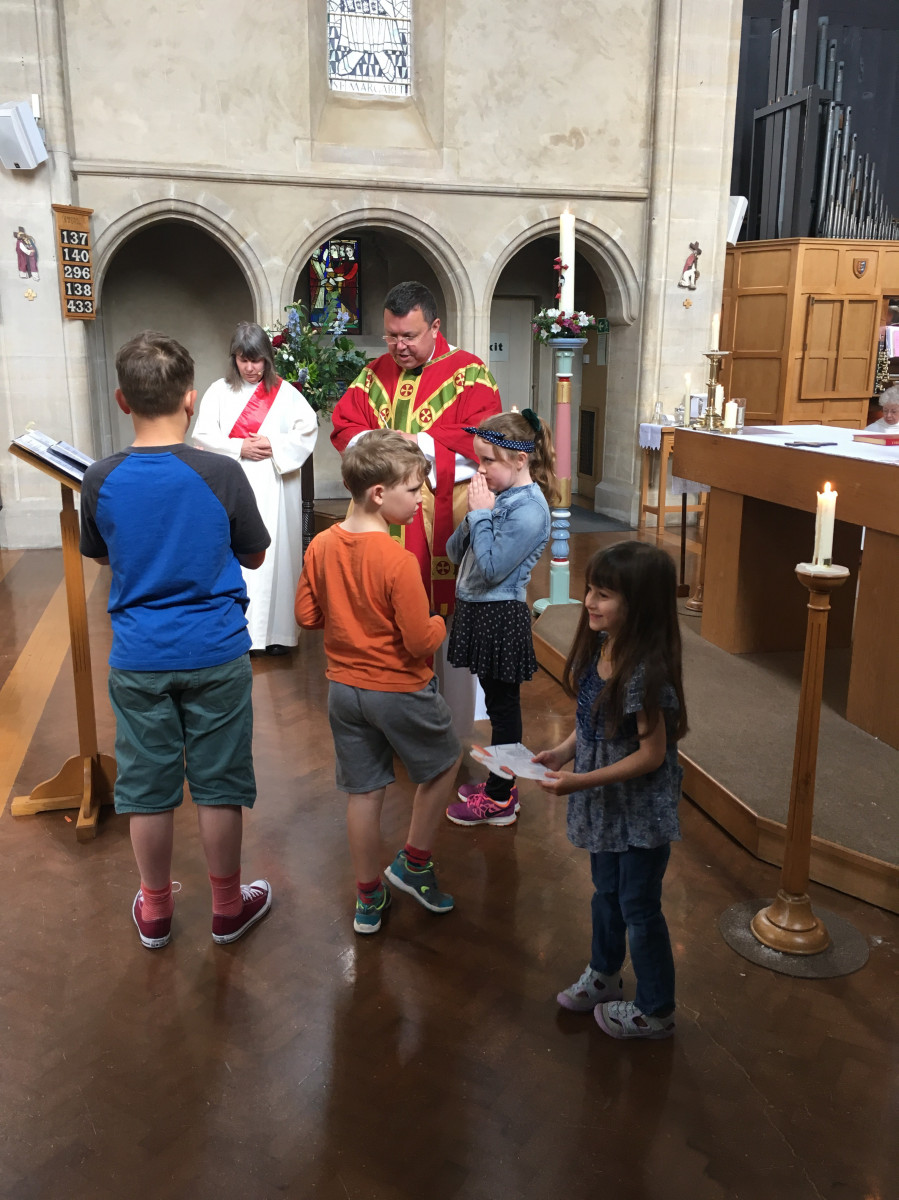 Priest, deacon and children in Sunday service