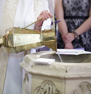 Priest fills font ready for baptism / christening
